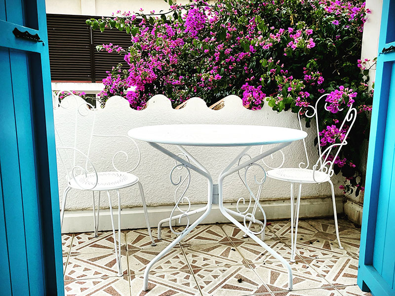 Le petit balcon de la suite de la Maison de parrain Le petit balcon avec sa table et ses chaises d'extérieur donnant sur le bougainvillet