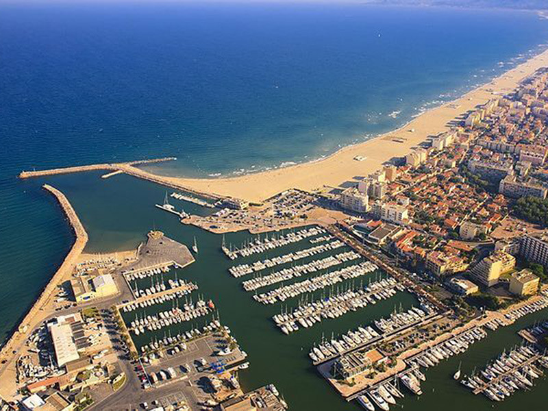 Vue aérienne de Torreilles Plage avec son port, sa grande plage de sable fin et le littoral méditerranéen des Pyrénées-Orientales.